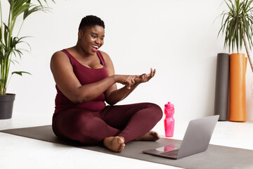 Wall Mural - Cheerful plump black woman yoga coach streaming from studio