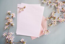 Cherry Blossoms Decoration With Blank Letter Paper. Hello Spring Background. Spring Message, Cherry Blossom And Letter On Green Background.