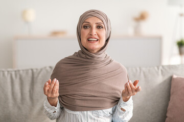 Wall Mural - Happy Senior Islamic Lady Talking Looking At Camera Indoor