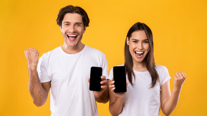 Couple showing two black empty smartphone screen and gesturing yes