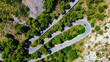 Aerial shot of winding road through mountain forests