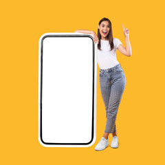 Wall Mural - woman showing white empty smartphone screen and pointing up