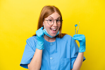 Wall Mural - Young redhead Dentist woman isolated on yellow background celebrating a victory in winner position