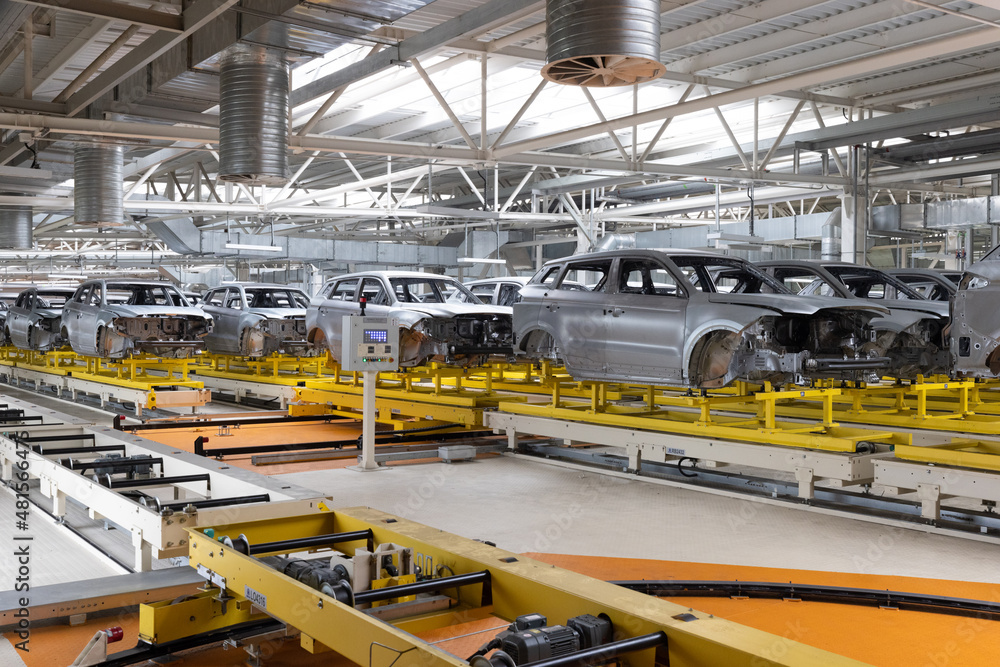 Car bodies are on assembly line. Factory for production of cars. Modern automotive industry