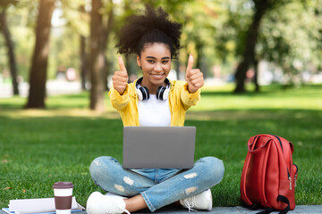 Wall Mural - Black Student Girl Posing With Laptop Gesturing Thumbs-Up Learning Outdoors