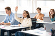 © Prostock-studio - Portrait of female student raising hand at classroom