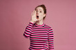 Studio shot of young woman screaming and standing on the pink background