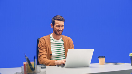 Poster - Green Screen Office Background: Caucasian Businessman Sitting at His Desk Working on a Laptop Computer. White Man working with Big Data e-Commerce Analysis.