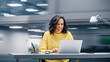 © Gorodenkoff - Modern Office: Happy Smiling Hispanic Businesswoman Sitting at Her Desk Working on a Laptop Computer Celebrates Victory. Latin Female Entrepreneur is a Happy Winner. Motion Blur Background