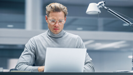Poster - Modern Office: Businessman Sitting at His Desk Working on a Laptop Computer. Digital Entrepreneur working with Big Data e-Commerce Project, Successful Startup. Blurred Background.