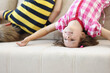 Children have fun at home, kids upside down on sofa, holiday at school