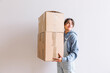 © ADDICTIVE STOCK - Positive woman carrying carton boxes