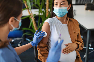 Wall Mural - Pregnant Asian Woman Preparing To Get Vaccinated Against Covid-19