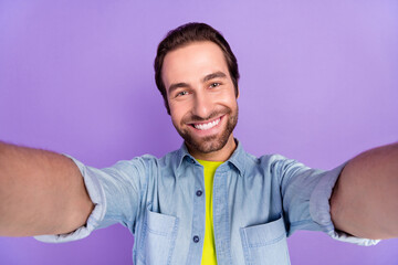 Wall Mural - Portrait of young handsome cheerful male take selfie record video vlog freelancer isolated on violet color background