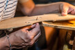 luthier violin maker working on a classic wooden hand made violin f holes in his workshop