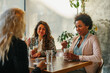 © bernardbodo - Three diverse women sitting at cafe
