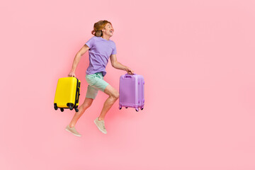 Poster - Full length body size view of attractive cheery guy jumping holding bags running low cost flight isolated over pink pastel color background