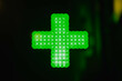 Świecący, zielony krzyż równoramienny oznaczający miejsce położenia apteki.