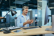 © Liubomir - Senior and experienced employee, advises the buyer on a video call, the man works in a modern office uses a headset for negotiations, and a webcam
