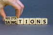 © Dzmitry - Sanctions or negotiations symbol. Businessman turns cubes, changes the word sanctions to negotiations. Beautiful grey table, grey background, copy space. Business, sanction or negotiation concept.