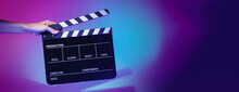 Blurry Images Of Movie Slate Or Clapper Board. Hand Holds Empty Film Making Clapperboard On Color Background In Studio For Film Movie Shooting Or Recording. Film Slate For Youtuber Video Production.