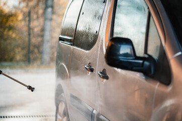 Sticker - Manual car wash with white soap, foam on the body. Washing Car Using High Pressure Water.