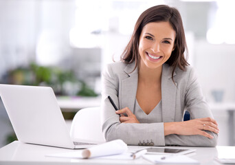 Wall Mural - She's made it. Shot of an attractive businesswoman sitting at her desk in an office.