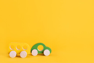 Wall Mural - Wooden toy car in cartoon style on yellow background. Colorful and Transportation background, eco kid toys Montessori . 