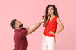 © Pixel-Shot - Young man proposing to his girlfriend on color background