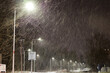Mocny opad śniegu w nocy w świetle latarni