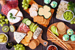 St Patricks Day theme charcuterie table scene against a wood background. Variety of cheese, meat, fruit and vegetable appetizers. Top view.