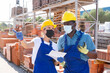 © JackF - African male worker with european woman in masks keep track of the number of redbricks at the site of hardware store