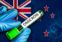 New Zealand Outbreak Of Omicron Variant. Hand Holds A Test Tube With Covid-19 Virus Omicron In Front Of New Zealand Flag