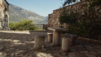 Wall Mural - Moving around an ancient greek table in golden sunlight and beautiful landscape in the background