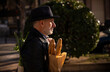 © WeeKwong - Adult man in hat holding bread and vegetable bag on street. Madrid, Spain