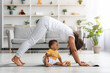 © Prostock-studio - Young black mother practicing yoga at home with her infant son