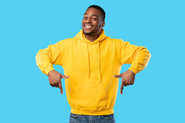 Wall Mural - Happy Black Guy Pointing Fingers Down Standing On Blue Background