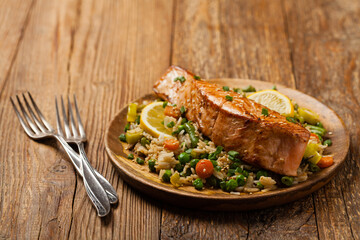 Wall Mural - Asian dish. Fried salmon with rice and vegetables. Sprinkled with sesame seeds.