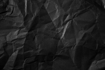 Textured crumpled black paper background.