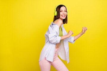 Wall Mural - Photo of cool bob hairdo young lady dance wear headphones green singlet shirt isolated on yellow background