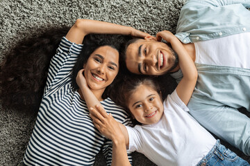 Wall Mural - Closeup portrait of happy middle-eastern family cuddling on floor