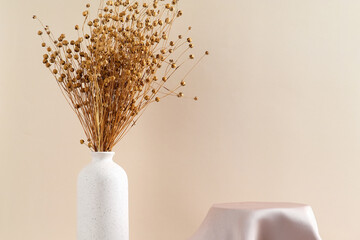 Wall Mural - Satin cloth product display podium with vase of dried flax flowers on beige background. Product presentation concept. Minimal style.