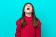Little caucasian girl isolated on blue background looking up and with surprised expression