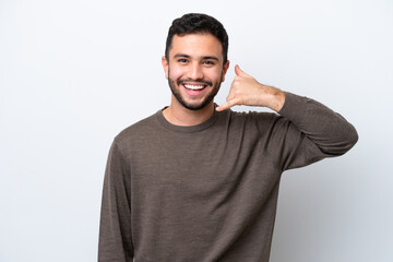 Young Brazilian man isolated on white background making phone gesture. Call me back sign