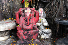 Red Sculpture Of The Indian God Ganesha Under A Tree. A Makeshift Hindu Altar Outside.