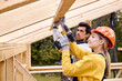 © alfa27 - contractors in work wear using electric drill. Home renovation, sustainable living, building cottage house. Building Technologies. Industrial Theme. Two builders in uniform and hardhat work as team