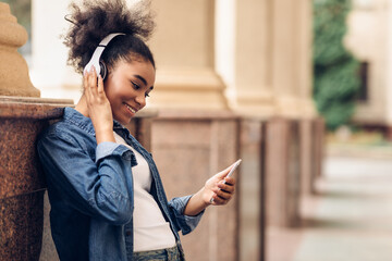 Wall Mural - African Teen Girl Using Phone Listening Music Wearing Headphones Outdoors