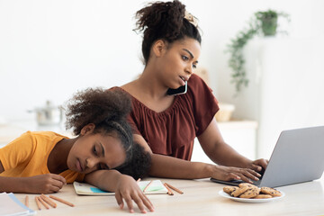 Wall Mural - Bored teen girl sitting by her working mom, kitchen interior