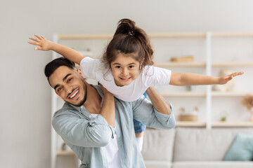 Wall Mural - Happy middle-eastern family playing together at home