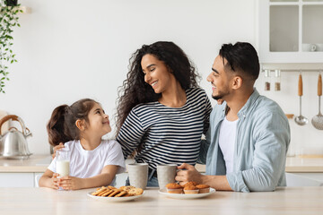 Wall Mural - Cute happy family having breakfast while spending weekend at home